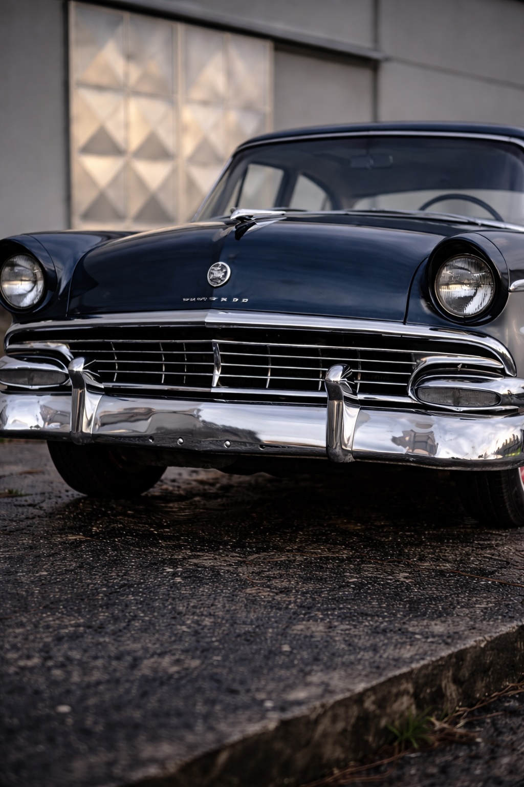 Dettaglio frontale Ford Customline 1956 con griglia cromata, paraurti e fari anteriori d’epoca.